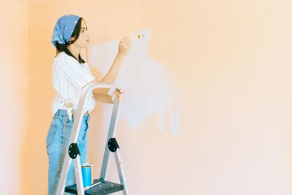 Interior painting in Allentown: painter on a stepladder rolling a wall